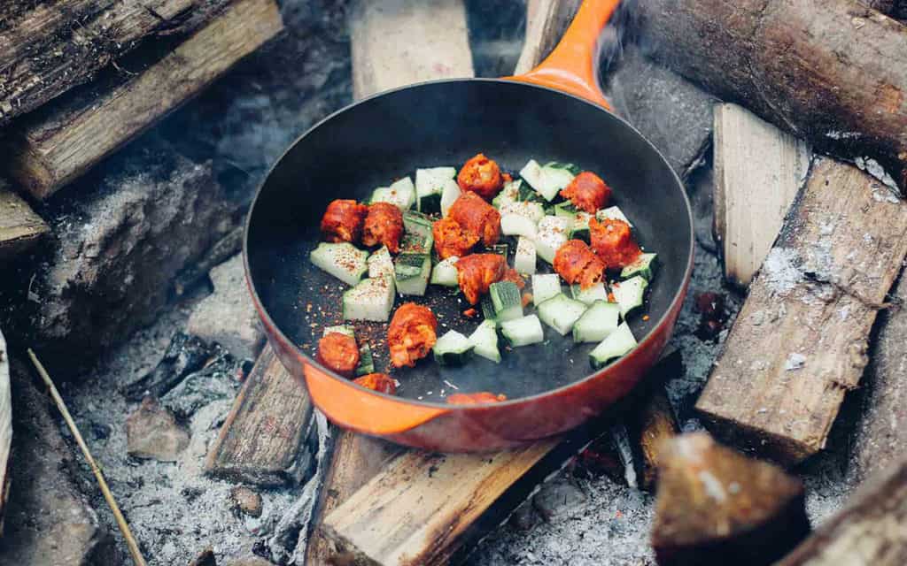 orange frying pan with fresh vegetables to depict the journal to living naturally.