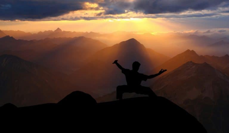 What is Tai Chi? The Basics. Figure doing a pose at sunset.
