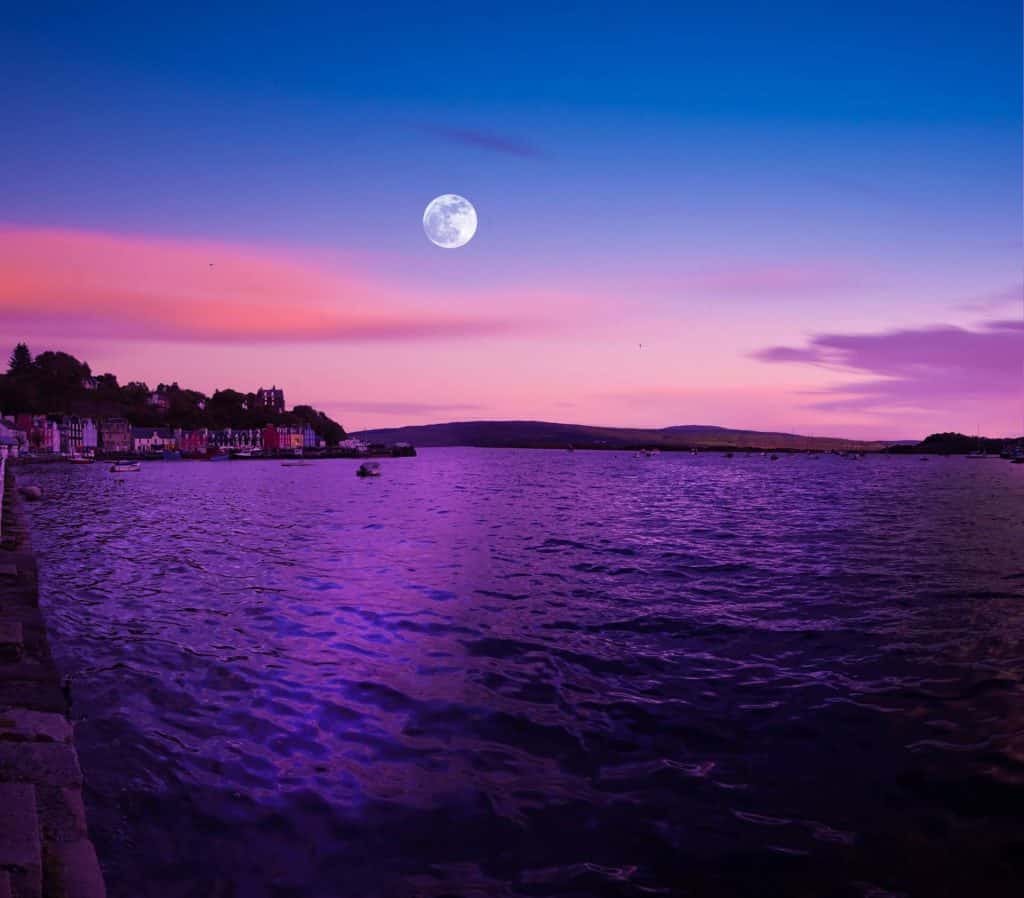 Full moon in Aries over a lake with a lovely pink sunset.