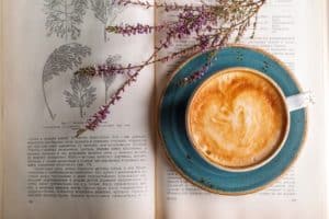 open book with coffee and lavendar laying on the page 