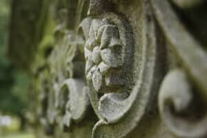 Close up detail of a grave marker carving. Swirls and flowers. 