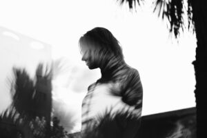 girl and tree in a fuzzy black and white shadowy image for shadow work 