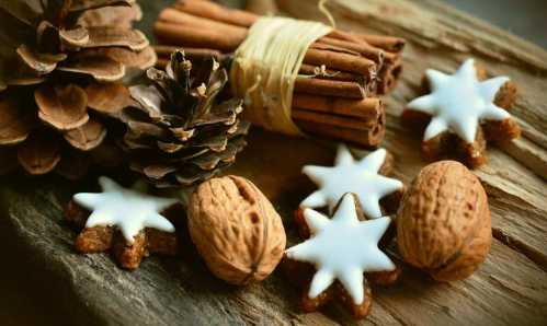 hygge for the witch includes natural elements - walnuts, cinnamon sticks, pinecones and cookies on a wooden table shown here 