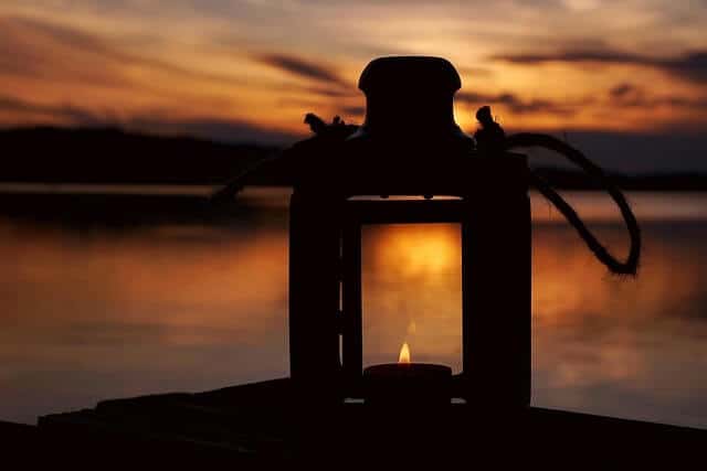 square lantern with a candle inside shown at sunset. simple and magickal 